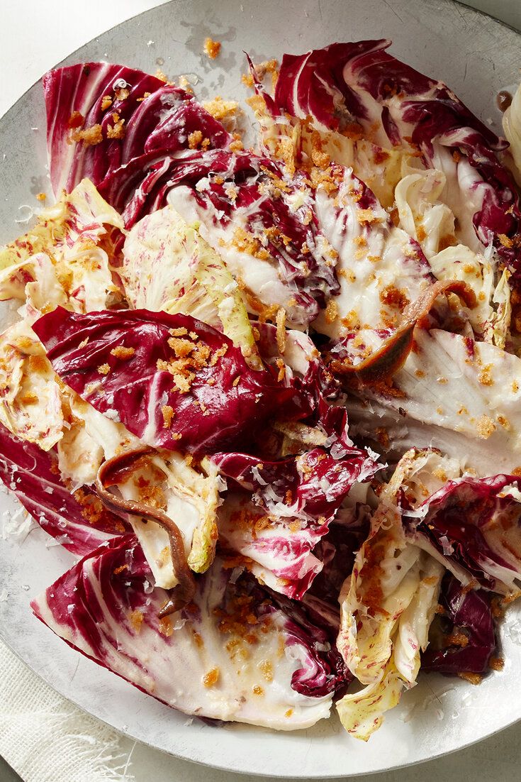 a white plate topped with red cabbage covered in sauce and crumbled on top