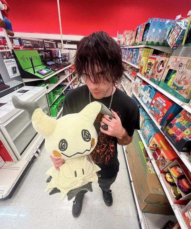 a man holding a stuffed animal in a store