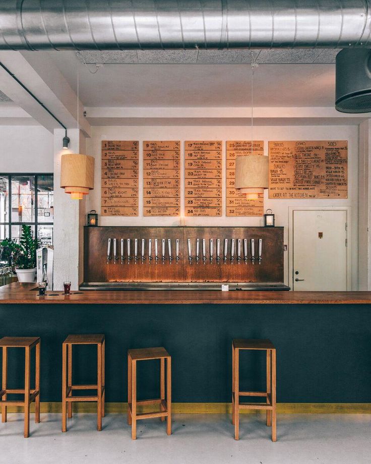 an empty bar with three stools in front of it