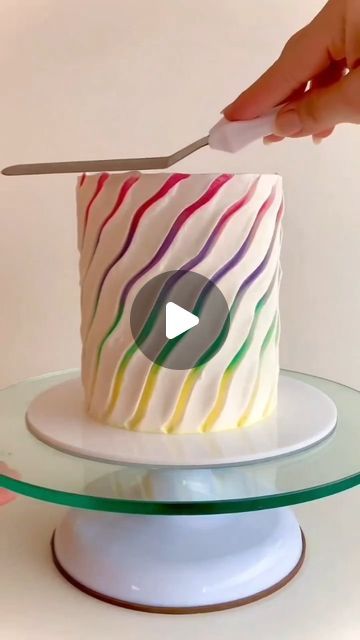 someone is cutting into a colorful cake with a knife