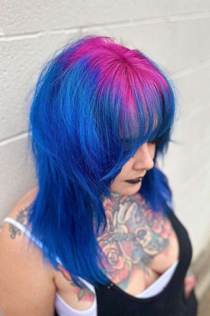 Witness the striking combination of bright pink roots and blue hair with bangs on the right side of this person's head! 💖💙 Embrace your adventurous side and make a statement with this eye-catching hairstyle. Ready to stand out from the crowd? Book your appointment now and let's create your own unique look! #BrightPinkRoots #BlueBangs #ColorfulHair #HairInspiration #BookNow #HairMagic Roots Different Color Hair, Unique Vivid Hair Color, Blue Hair Pink Bangs, Blue Hair With Pink Tips, Hair Dye Ideas Bright, Pink And Blue Hair Dye Ideas, Hair Color Ideas Crazy, Blue Hair Pink Tips, Pink And Blue Short Hair