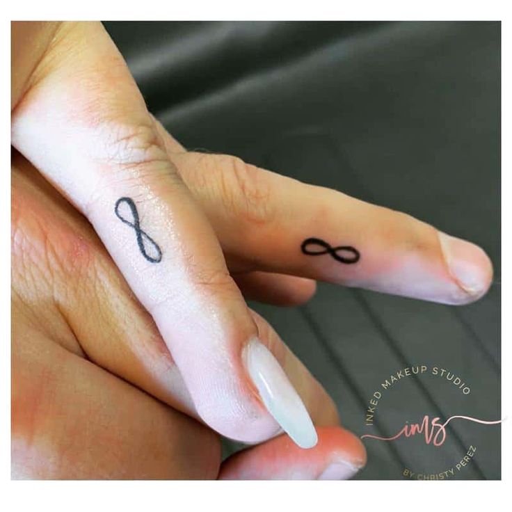 a woman's finger with an infinite symbol tattoo on it