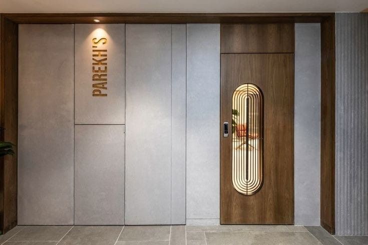 the entrance to a modern office building with an art deco door and planter on the wall