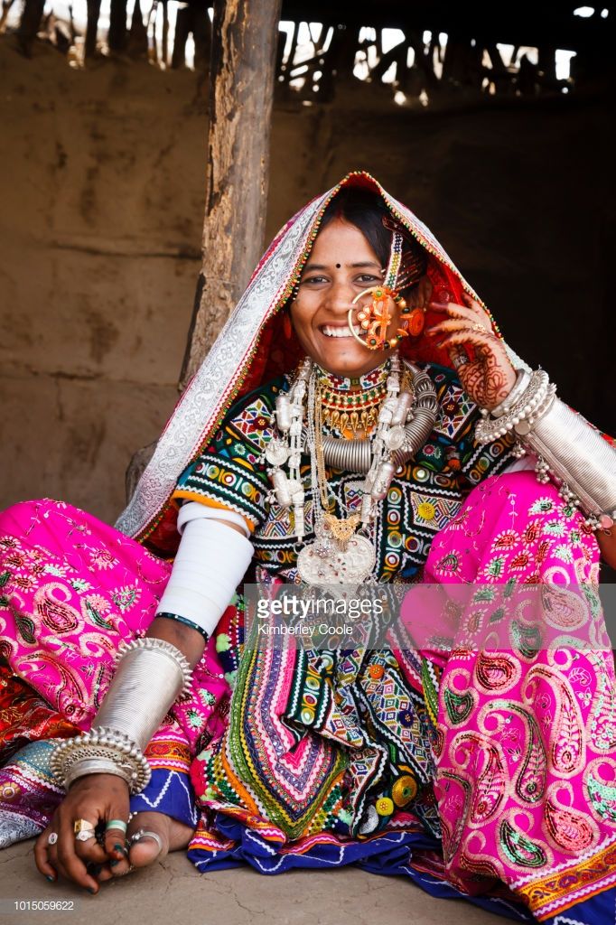 a woman in colorful clothing sitting on the ground