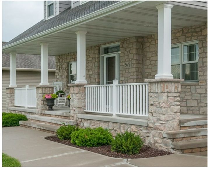 the front porch of a house with white columns