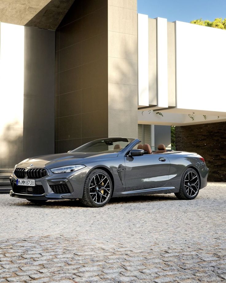 a grey bmw z4 roadster parked in front of a building