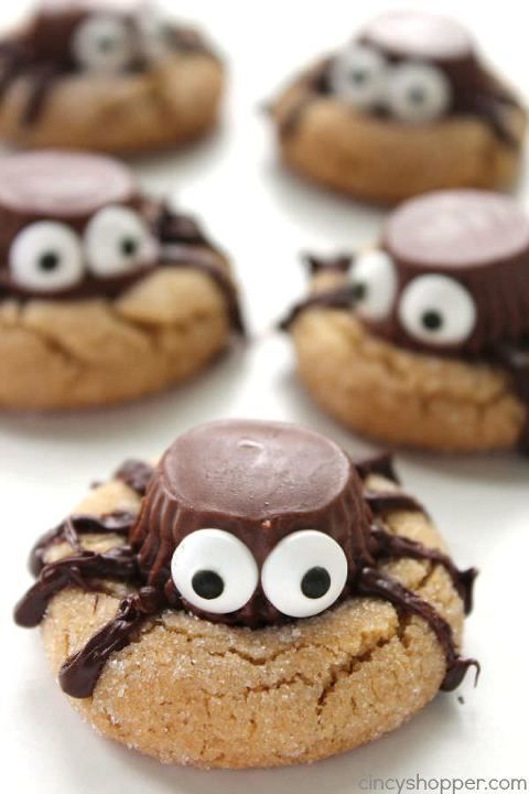 chocolate covered cookies with googly eyes and spider web on the top are ready to be eaten