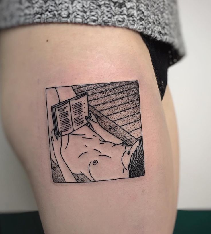 a woman with a book tattoo on her thigh is looking at the viewer's image