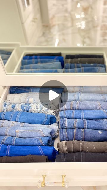 an open drawer with folded jeans in it