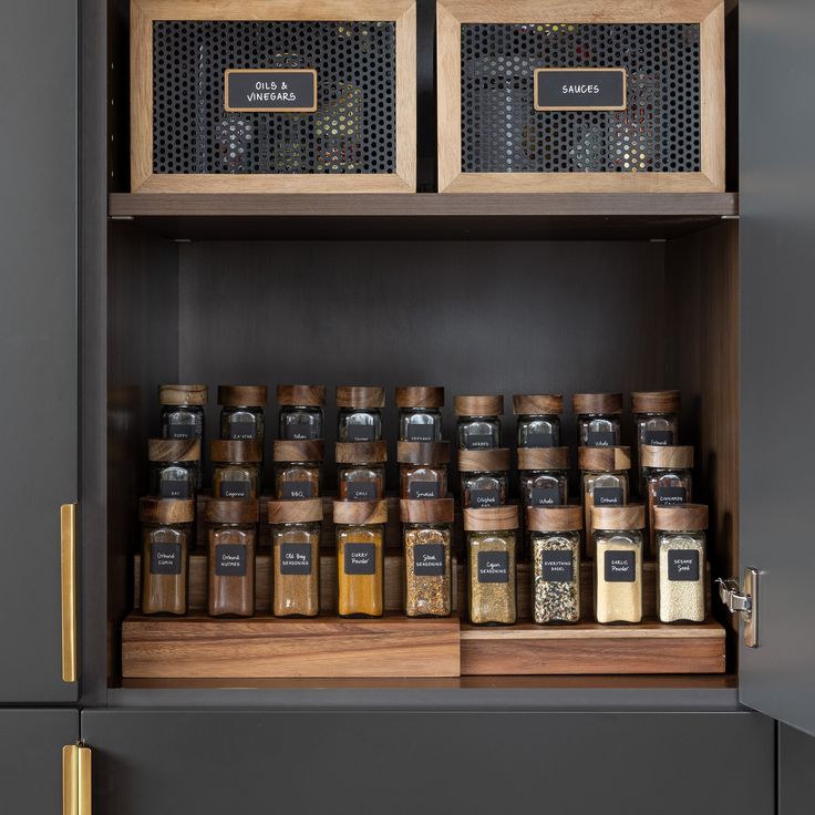 spices and seasonings are stored in wooden containers on top of the cupboards,