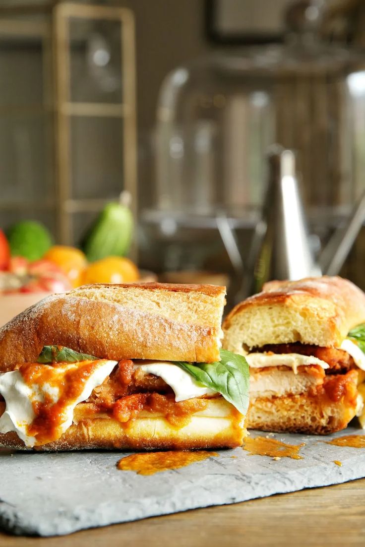 two sandwiches sitting on top of a wooden table