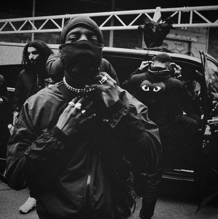 a black and white photo of a person with his mouth open in front of a car