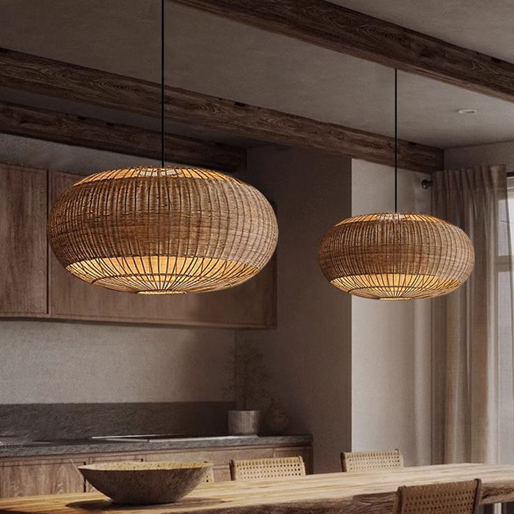 two lamps hanging from the ceiling above a dining room table with chairs and a bowl on it