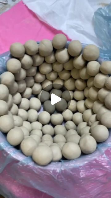 a bowl filled with eggs sitting on top of a plastic wrap covered table next to a pink cloth