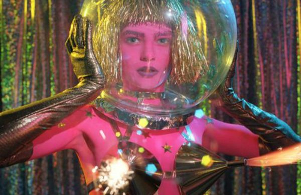 a woman in costume holding a crystal ball over her head