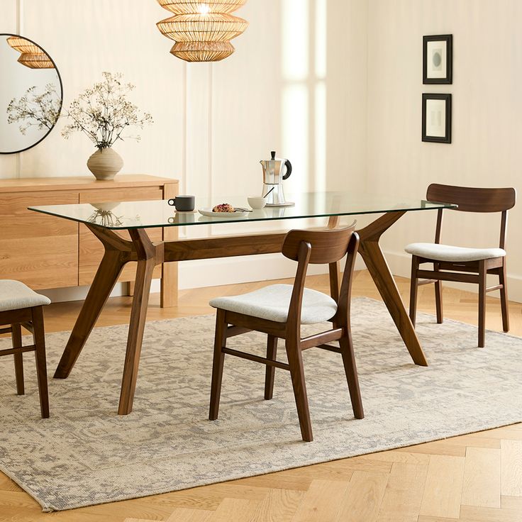 a dining room table with chairs and a rug on the floor in front of it