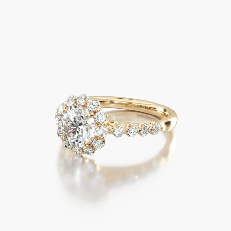 a yellow gold engagement ring with an oval cut diamond surrounded by small round brilliant diamonds