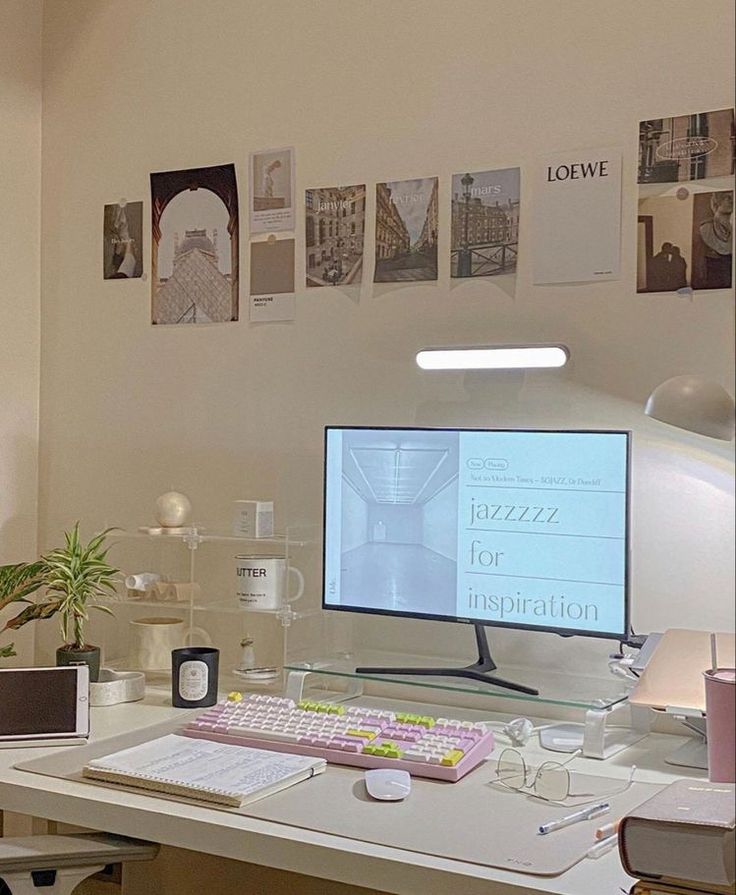 a desk with a computer monitor, keyboard and mouse on it next to a plant