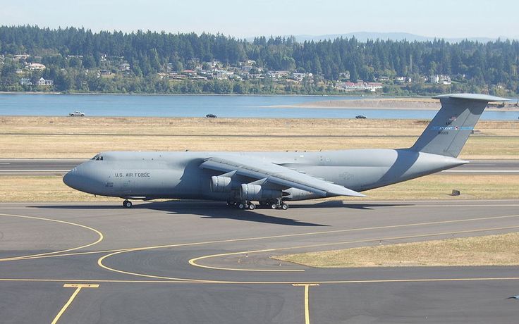 an air force plane is parked on the tarmac at an airport with water in the background