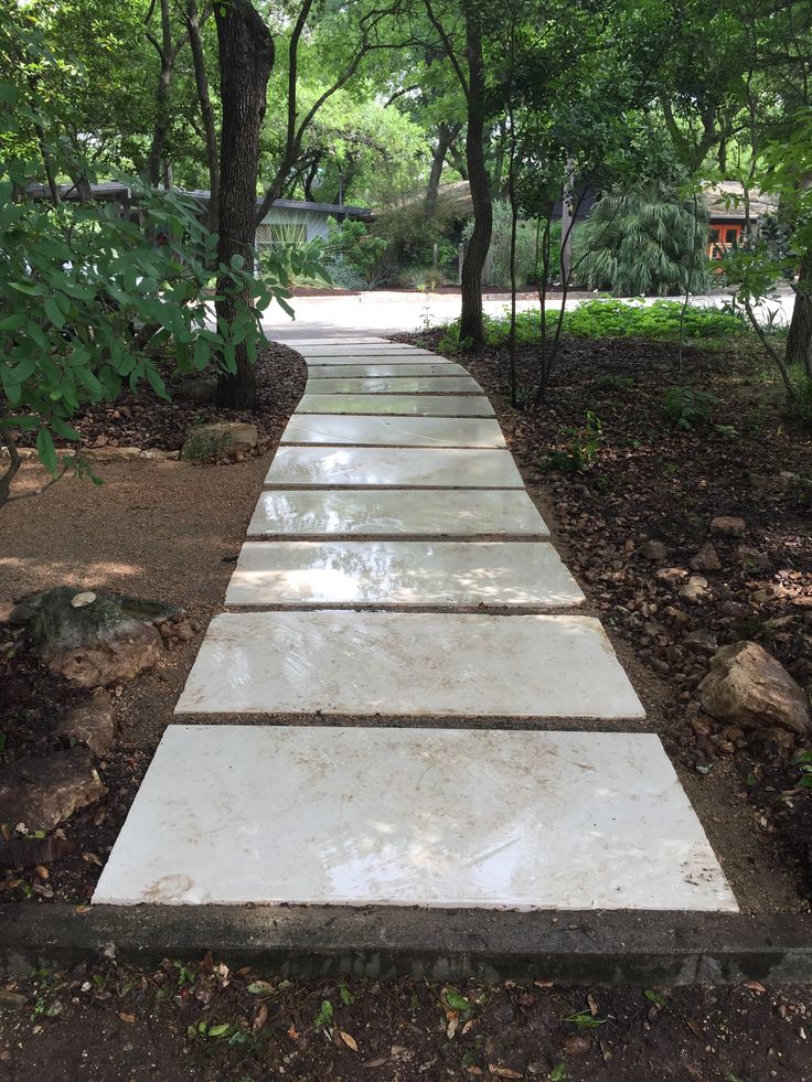 a stone walkway in the middle of a park