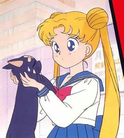 sailor girl with long blonde hair holding a black cat