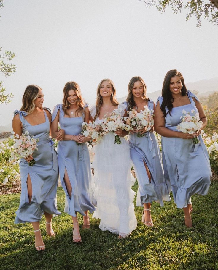 the bride and her bridesmaids are all dressed in blue dresses with white bouquets