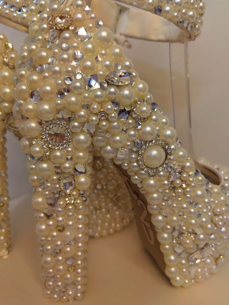 a pair of high heeled shoes made out of pearls