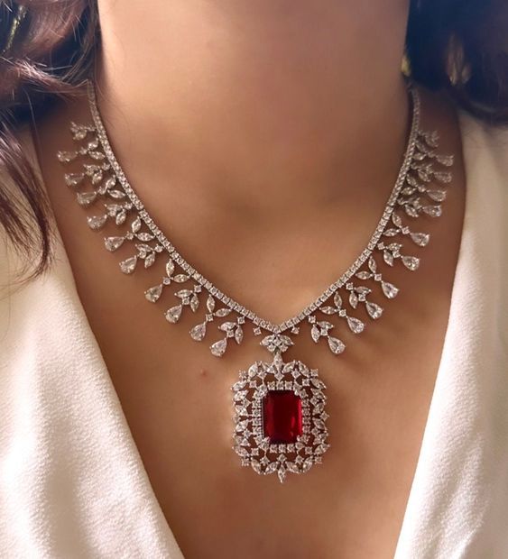 Add a touch of glamour and sophistication with this high quality red ruby pendant necklace set in beautiful zirconia stones. The stones in this set bling and look close to the real thing. This set is sure to make heads turn!  It features an adjustable necklace and a pair of earrings. It can be paired perfectly with both ethnic and western outfits.  Gorgeous fine quality Emerald CZ lab diamonds studded pendant set  in White gold plating and matching Earrings  *Comes with Statement matching earrin Diamond Sets Necklace Jewellery, Luxury Oxidized Jewelry For Engagement, Luxury Traditional Necklaces For Marriage, Luxury Traditional Necklace For Marriage, Luxury Rose Cut Diamond Jewelry Sets For Wedding, Luxury Fusion Style Ruby Necklace, Luxury Multi-stone Necklace For Wedding, Luxury Engagement Necklaces For Valentine's Day, Luxury Bollywood American Diamond Danglers