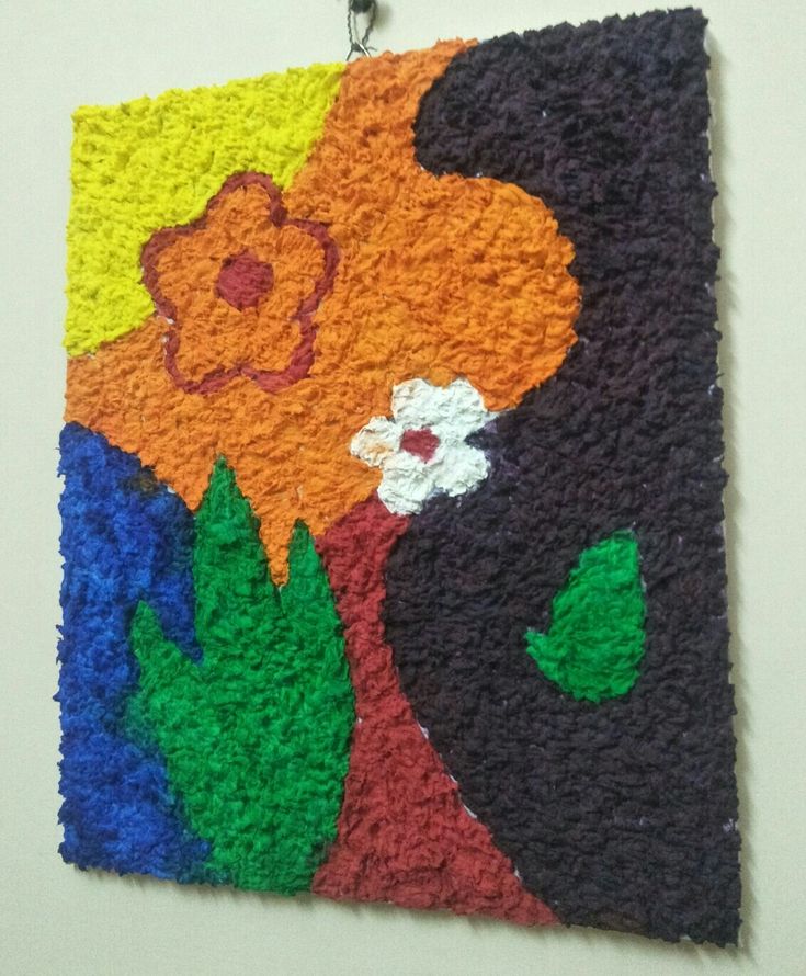 a painting made out of yarn with flowers on the front and back side, hanging on a wall