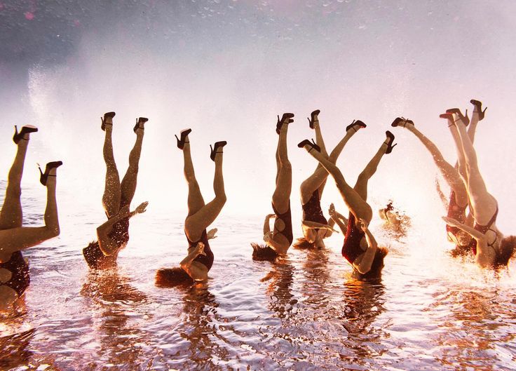 several people in the water doing different poses