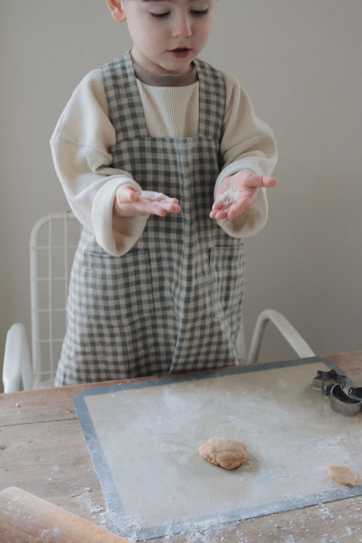 a little boy that is standing in front of a table