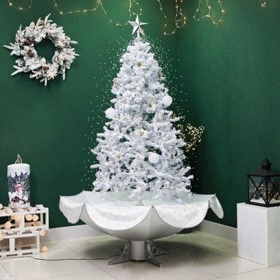 a white christmas tree sitting in the middle of a room with green walls and decorations