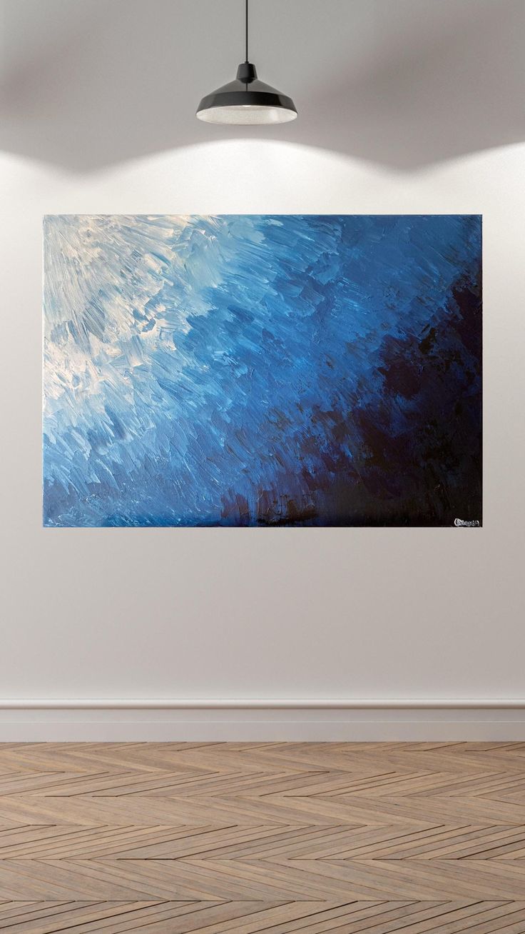 an abstract painting hangs on the wall above a wooden floor