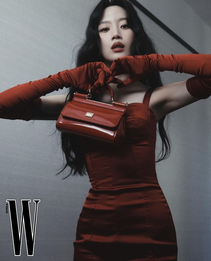 a woman in a red dress and gloves holding a handbag over her shoulder with the word w on it