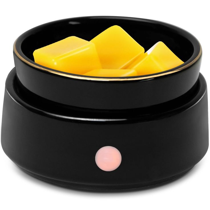 a black bowl filled with yellow cubes on top of a white table