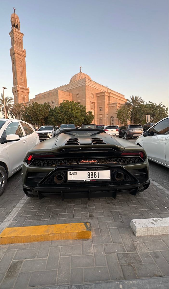 a black and white sports car parked in a parking lot next to some other cars