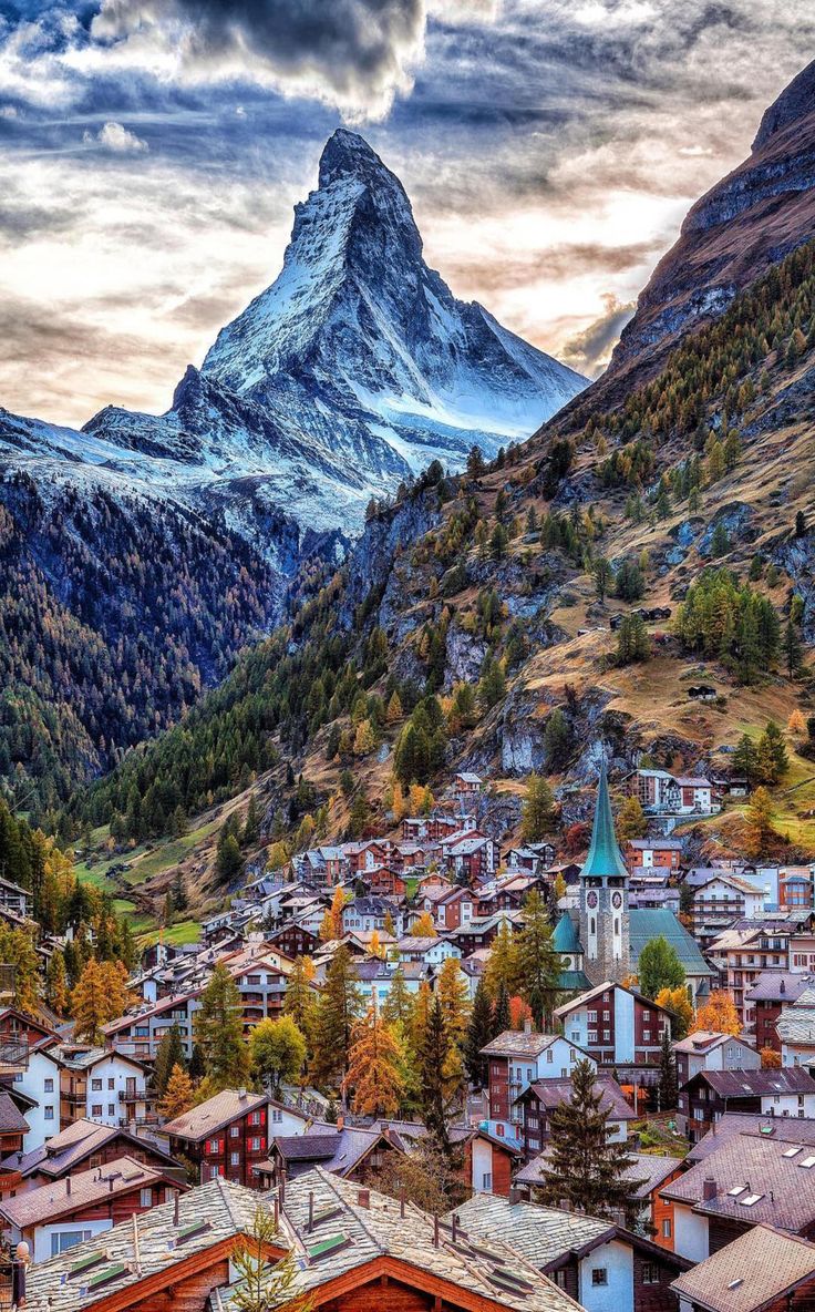 the mountains are covered in snow and trees, with houses on each floor below them