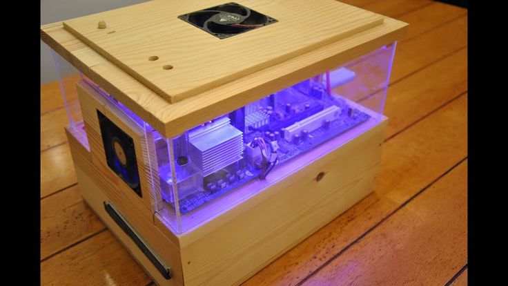 a wooden case with a purple light inside it on a wood table next to a wall