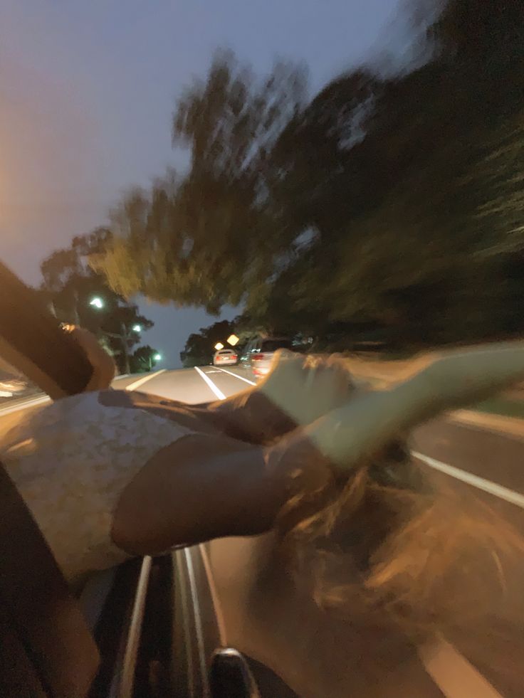 a person riding in the back of a car at night