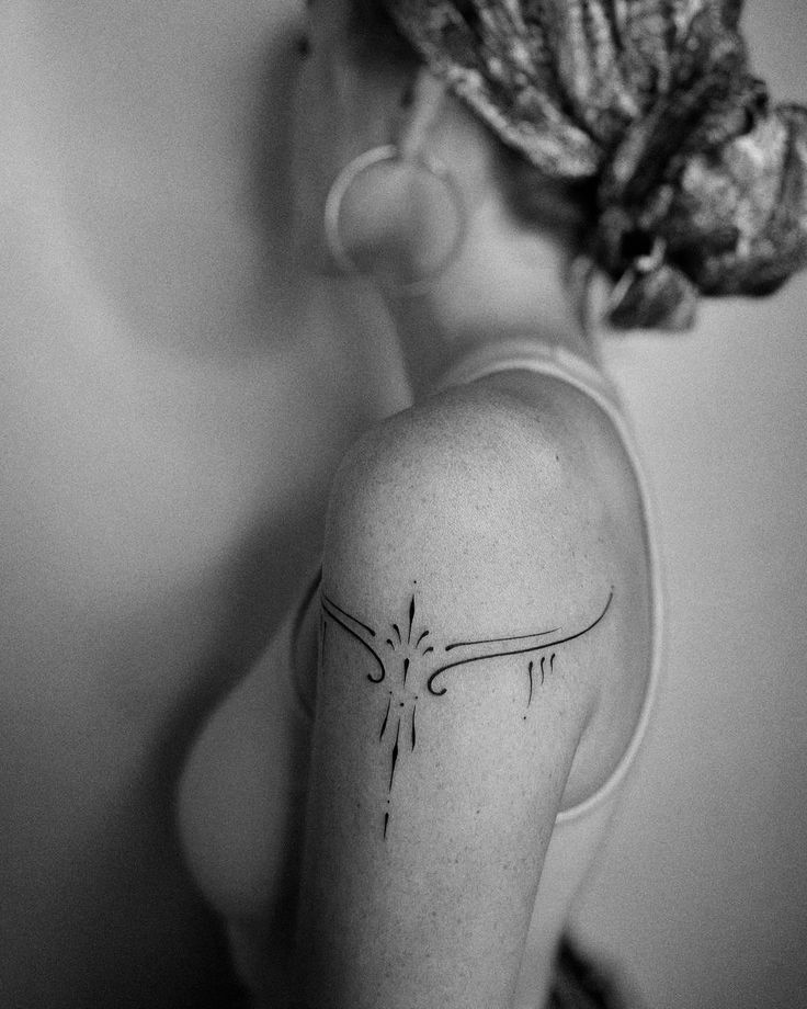 a woman with a tattoo on her back shoulder and behind her head is a flower