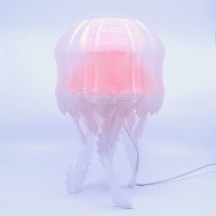 a pink jellyfish lamp on a white background with the light turned on and red