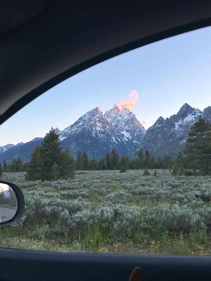 the mountains are in the distance as seen from inside a car