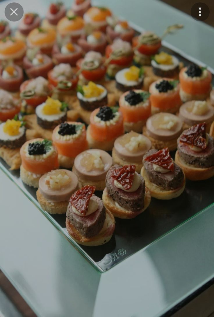 an assortment of appetizers are displayed on a glass platter, ready to be eaten