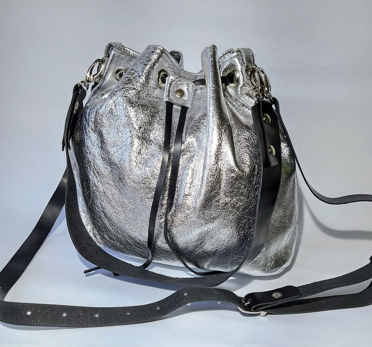 Discover the elegance of our Leather bucket bag silver, the perfect combination of style and functionality. This bag is perfect for any woman who appreciates sophisticated accessories. Our Small crossbody bag with drawstring offers a comfortable and stylish solution for everyday life, combining compactness and convenience. For those looking for something special, we present our Silver pouch with long strap. This sophisticated bag is perfect for a night out or special occasion, adding a touch of glamor to any look. Our Shoulder bag tote is designed with practicality and style in mind, offering enough space for all your everyday needs. Our Leather tote for womens is the perfect solution for those looking for a durable and elegant bag. Crafted from high-quality leather, this bag is perfect fo Cheap Silver Shoulder Bag For Travel, Affordable Silver Travel Shoulder Bag, Elegant Bags, Bag Silver, Chic Leather, Leather Bucket Bag, Leather Bucket, Small Crossbody, Small Crossbody Bag