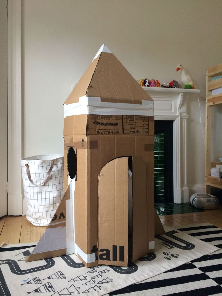 a cardboard house sitting on top of a black and white rug