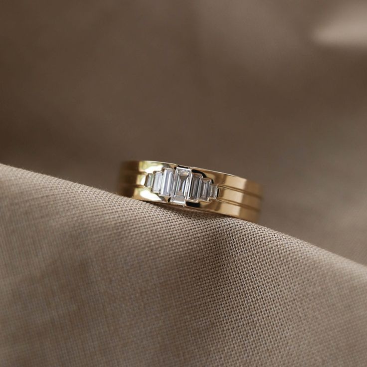 a gold wedding band with three baguettes on it