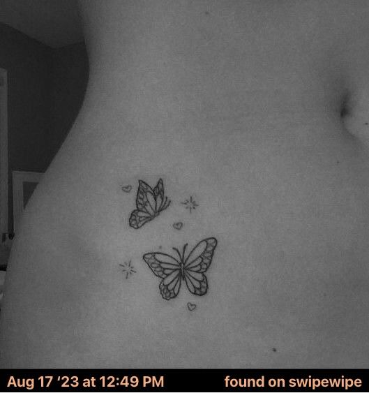 two butterflies on the back of a woman's stomach, one is black and white