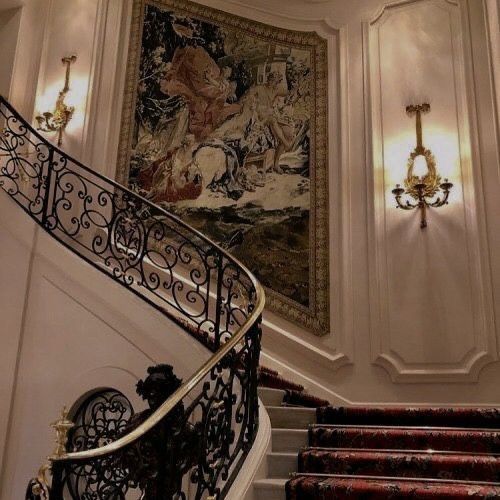 an ornate staircase with tapestry on the wall