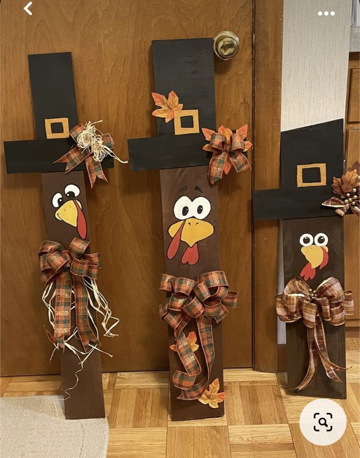 three scarecrows made to look like turkeys with hats and bows on their heads