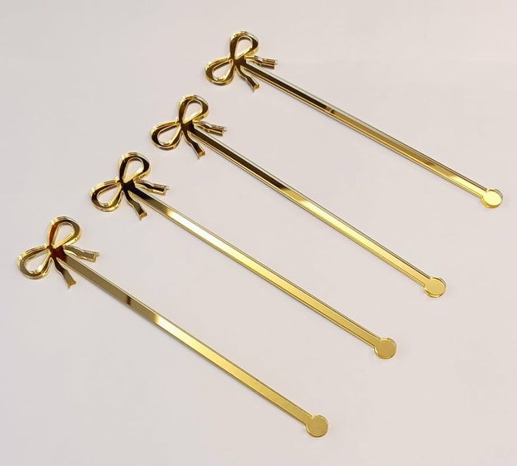 four pairs of gold colored scissors with bows on each end, and one pair of scissors in the middle